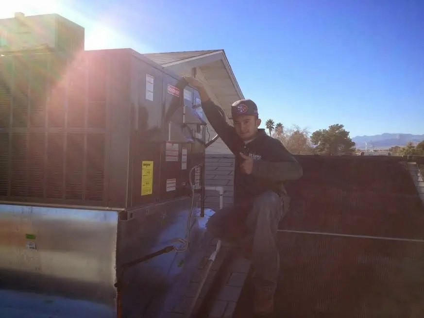 HVAC technician performing Boiler Repair on a rooftop unit in Murillo